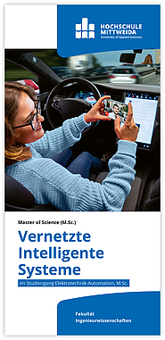 Eine junge Frau steuert ein autonomes Fahrzeug freihändig und hält ein Handy in der Hand.